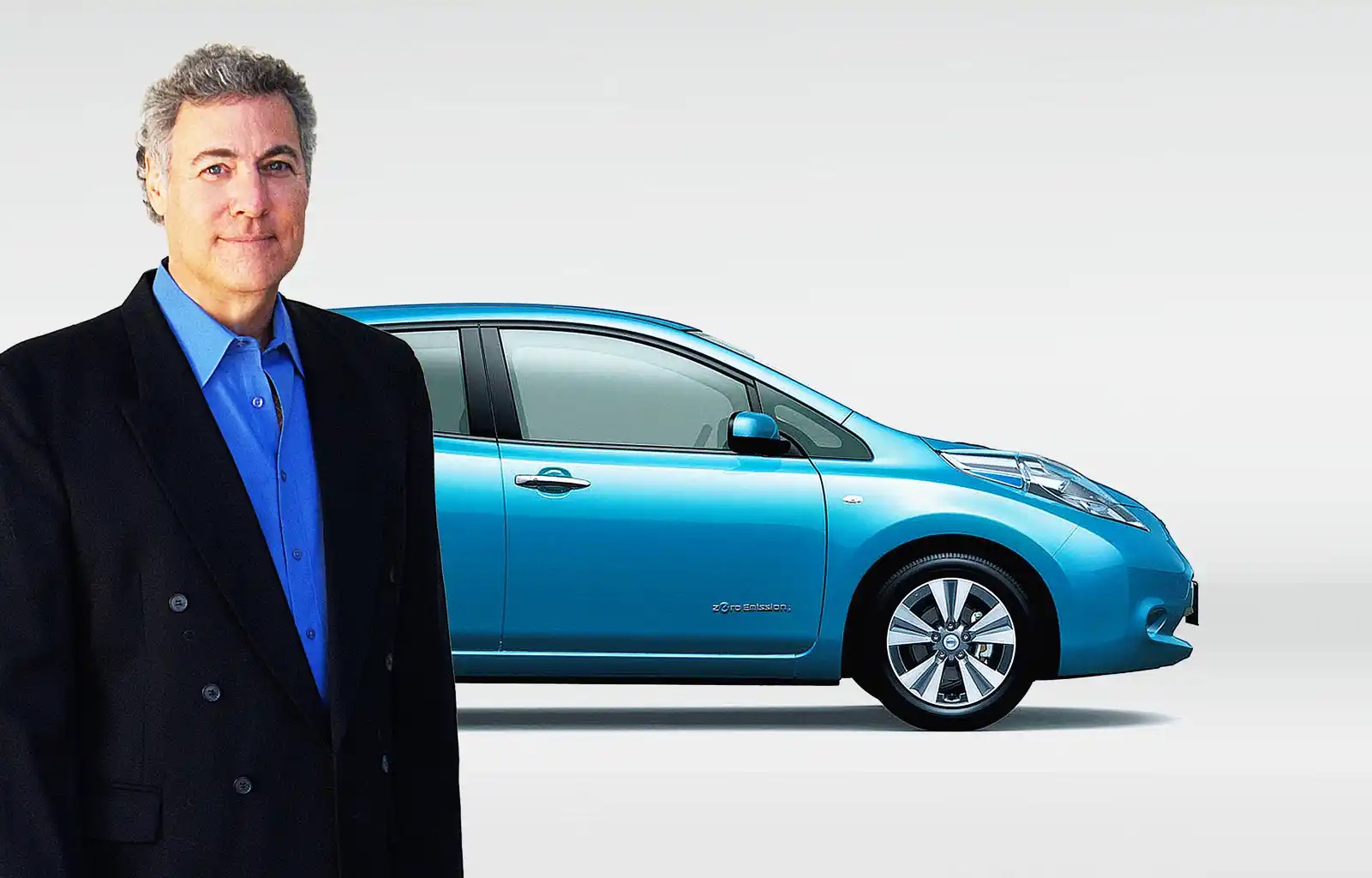David Eagle, founder of Current EV, standing beside a blue electric hatchback